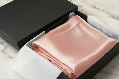jade satin pillowcase in a box on a light wooden surface